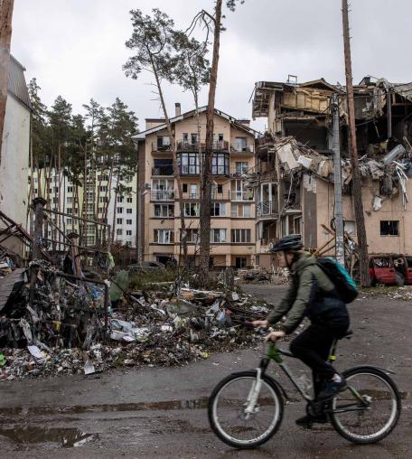 A man rides his bike past destroyed buildings on March 03, 2022 in Irpin, Ukraine. A man rides his bike past destroyed buildings on March 03, 2022 in Irpin, Ukraine.