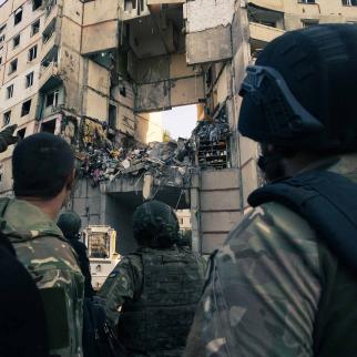 Military personnel look at the destroyed apartment block following an air strike, on September 24, 2024 in Kharkiv, Ukraine.